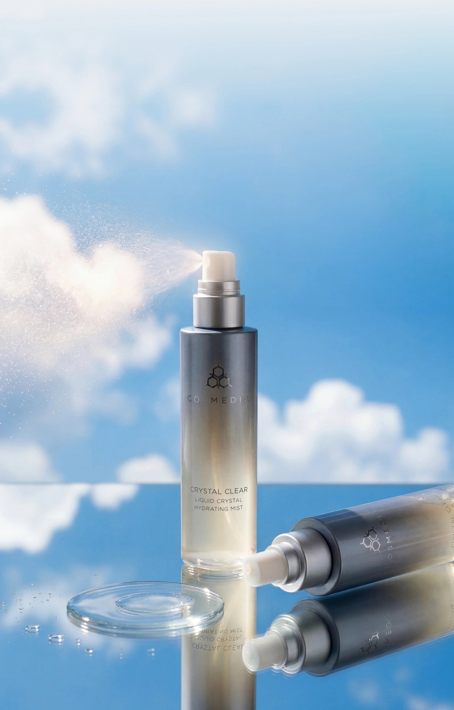 Crystal Clear Liquid Crystal ydrating Mist  against sky background and resting on mirrored surface with clear product swatch